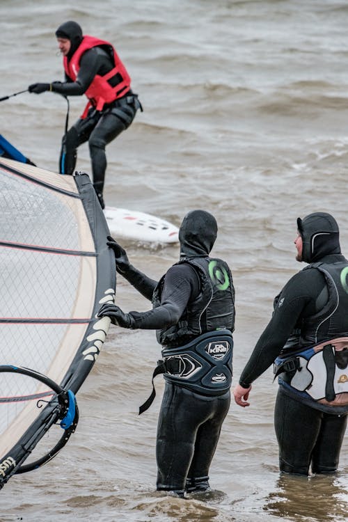 Men in Dive Suits Holding Surfing Equipment