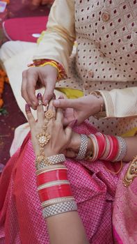Close-up of intricate jewelry and attire during a traditional Indian wedding ceremony emphasizing cultural richness.