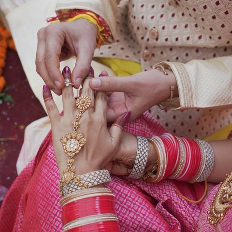 Man placing wedding ring on partner's finger
