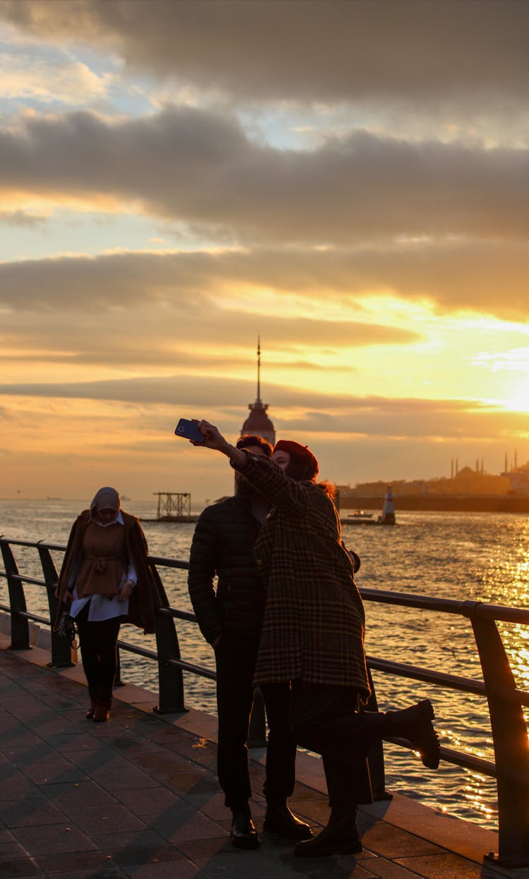 Couple Standing On Concrete Dock During Sunset