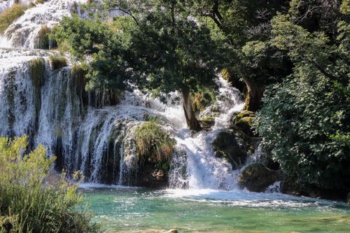 Free Beautiful waterfall amidst lush greenery, creating a serene and natural landscape. Stock Photo