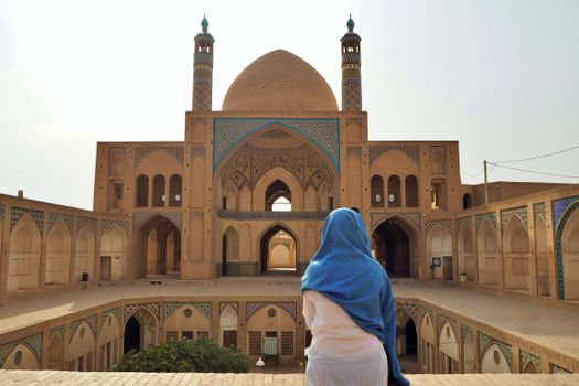 Woman in White Hijab Standing Near Brown Concrete Building