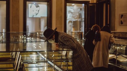Visitors viewing a glass exhibit case
