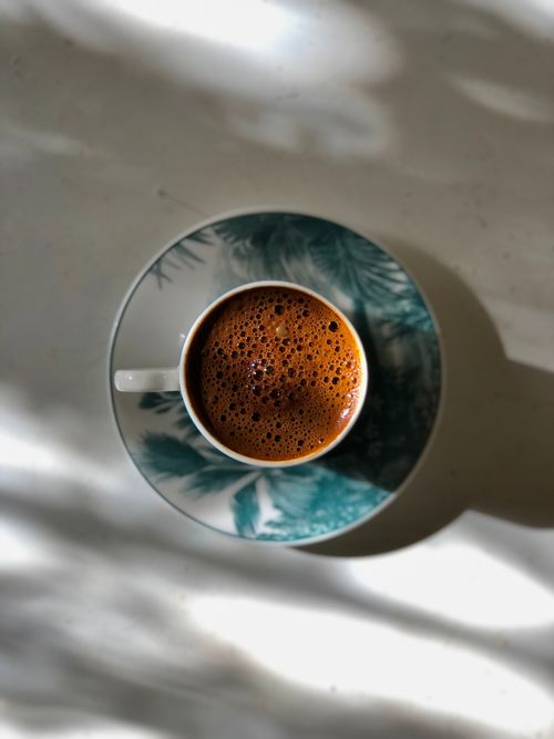 Free Top-down shot of traditional Turkish coffee in a decorative ceramic cup on a saucer. Stock Photo