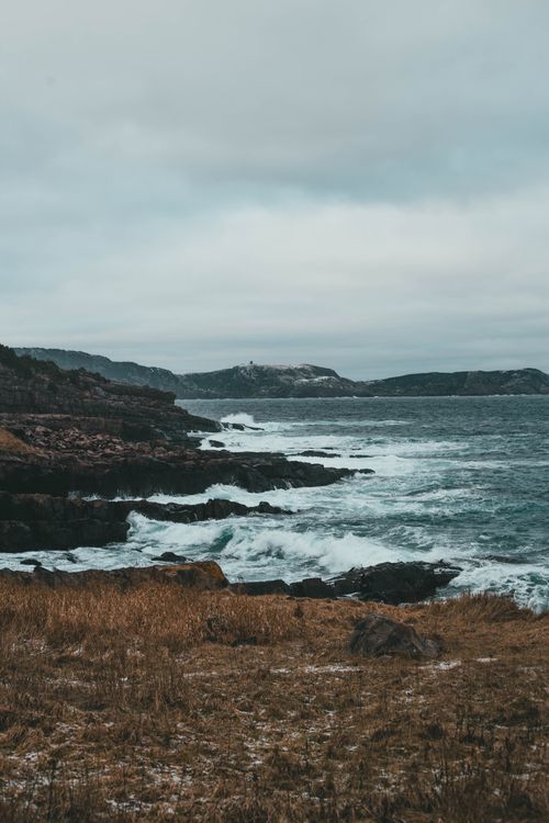 Free Explore the dramatic seascape of a rocky shoreline with powerful ocean waves under a cloudy sky. Stock Photo