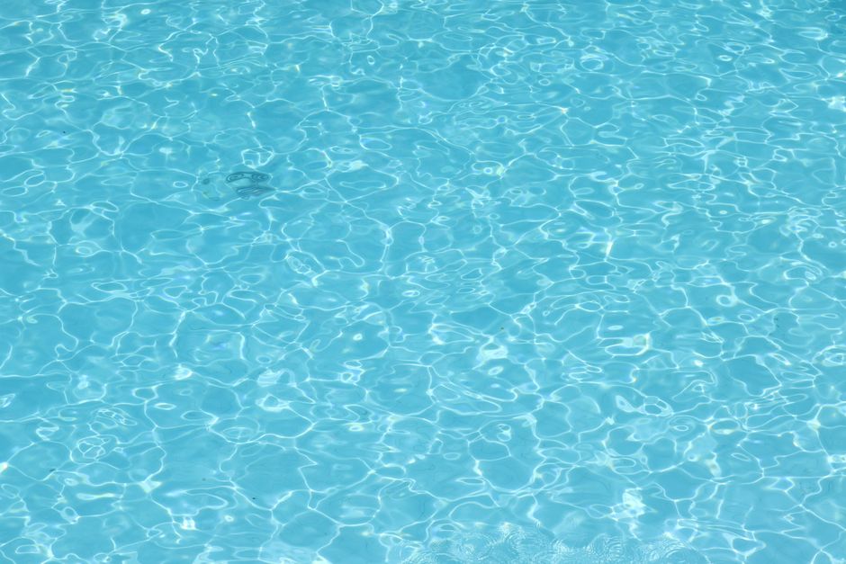Close-up of clear blue water ripples in a swimming pool, creating a calming texture.