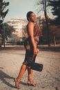 Woman in Brown Dress Holding a Black Leather Handbag