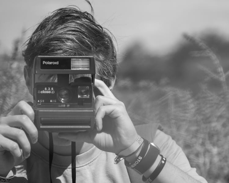 Photo Of Person Holding Polaroid Camera