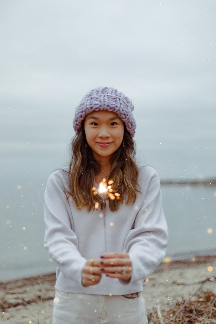 Smiling Woman On Beach Holding Sparkler