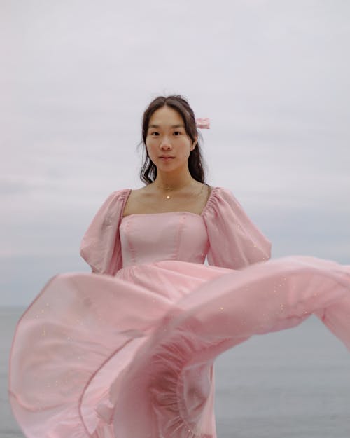 Woman Wearing Pink Dress with Puff Sleeves and Ribbon in Hair