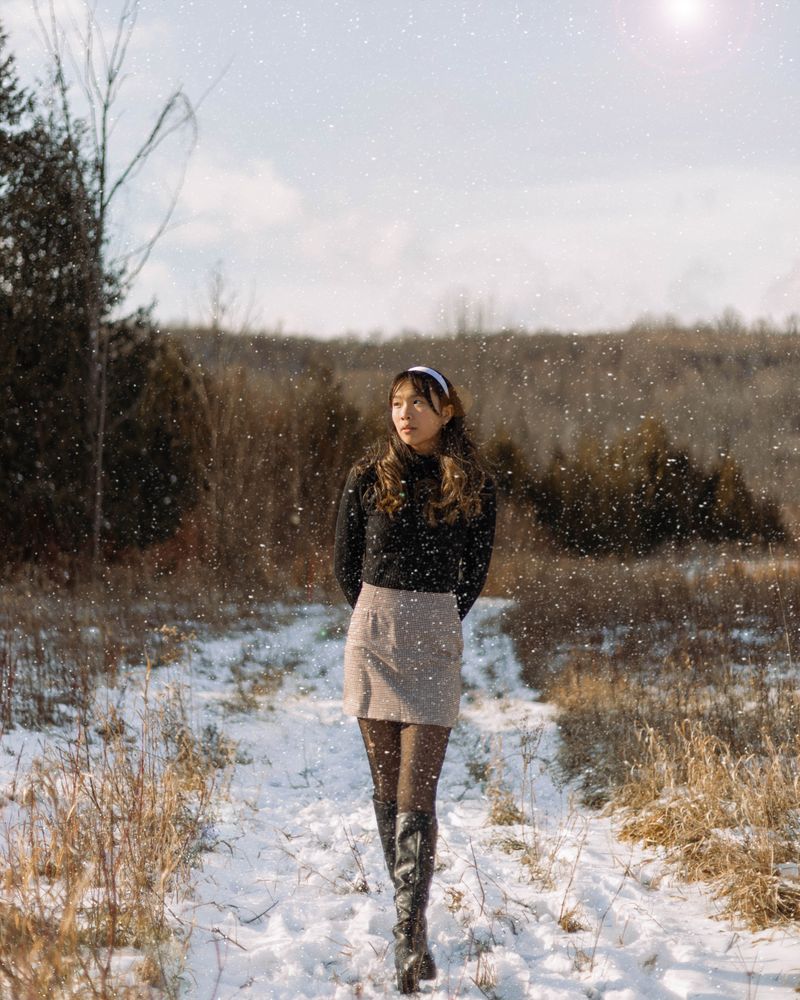 Woman in black sweater walking through snow