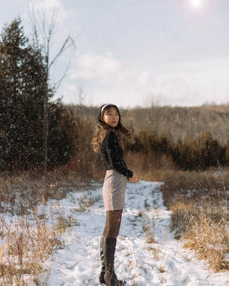 Woman Standing On Path Covered In Snow