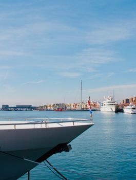 A serene view of luxury yachts in a harbor under a clear blue sky, ideal for travel brochures.
