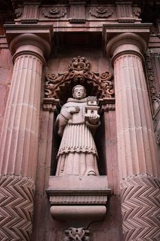 Detailed stone sculpture in classical architecture with ornate carvings and columns.