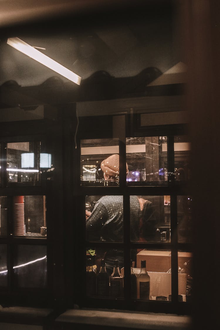 Man Working At Cafe Seen Through Window