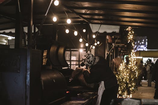 A bustling night market scene with a person grilling food under string lights, creating a cozy atmosphere.
