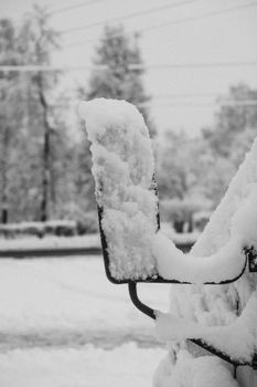 A close-up of a snow-blanketed car mirror in a serene winter setting.