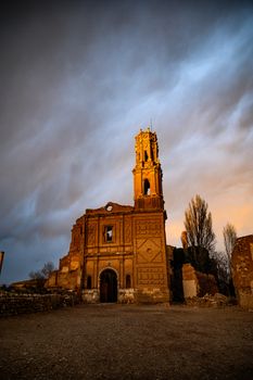 A captivating view of the church ruins in Belchite, Spain at sunset, showcasing a dramatic sky.