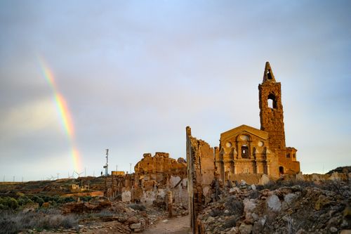 Free Scenic view of Belchite's historic ruins with a rainbow arching over the landscape. Stock Photo
