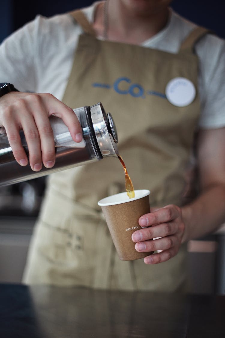 Hands Pouring Tea From Thermos To Cup