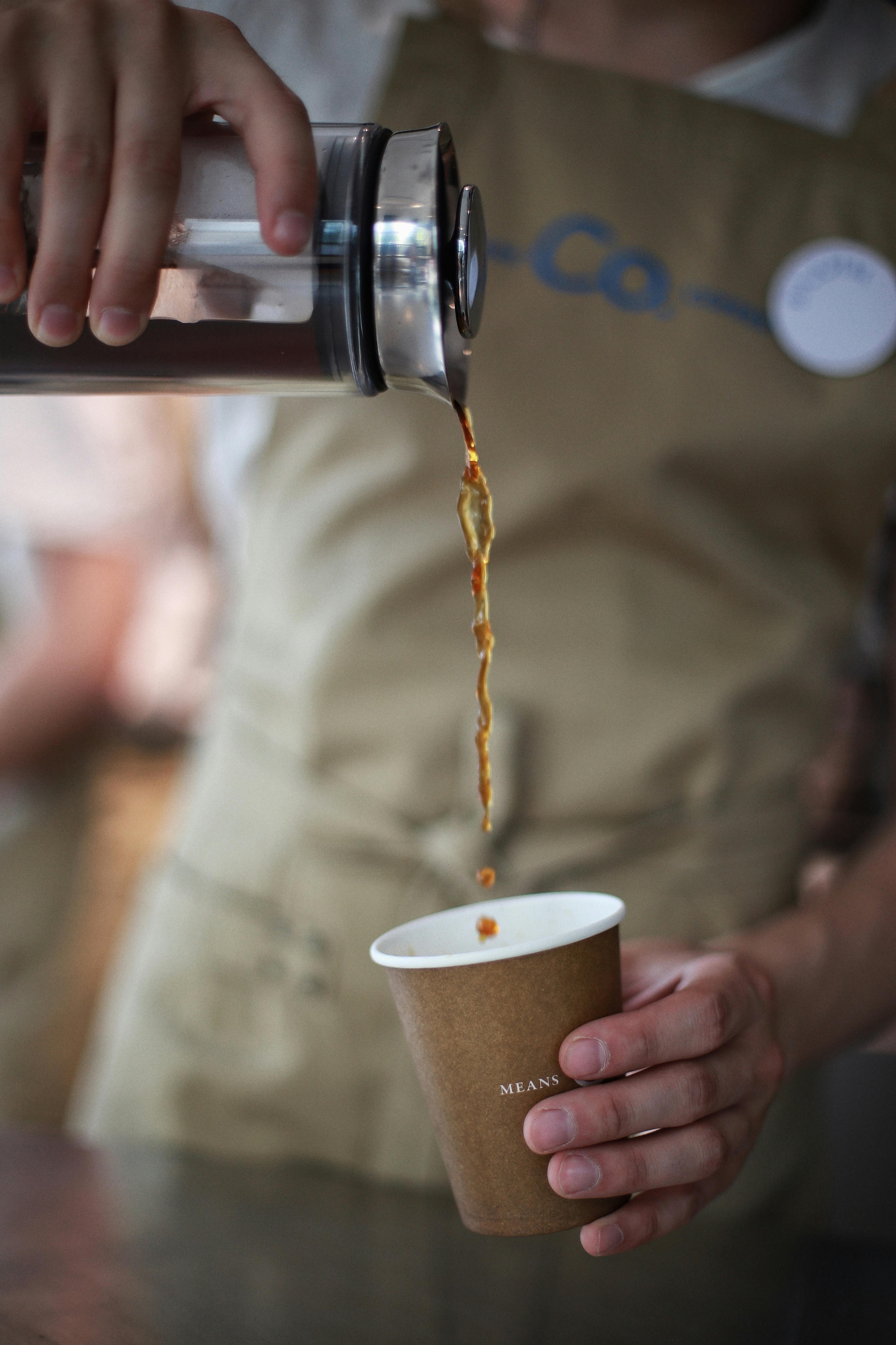 Barista Pouring Coffee into a Paper Cup · Free Stock Photo