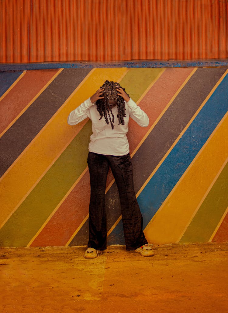 Person With Dreadlocks Posing By Colorful Wall