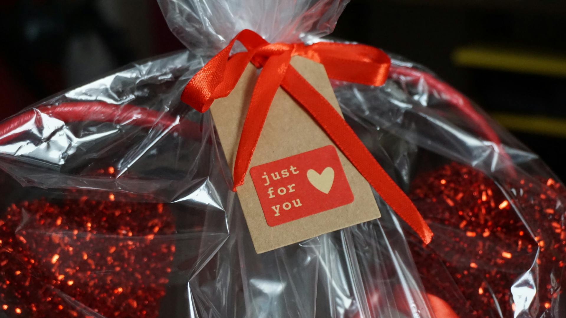 A beautifully wrapped gift basket with a red ribbon and 'just for you' tag, perfect for celebrations.