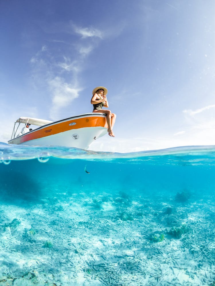 Woman Sitting At The Edge Of Yacht In Sea