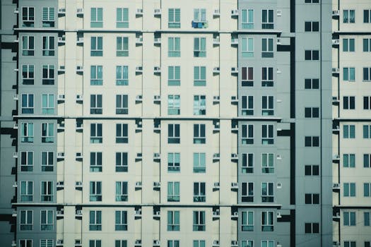 Symmetrical view of a modern urban residential building facade with geometric window patterns.