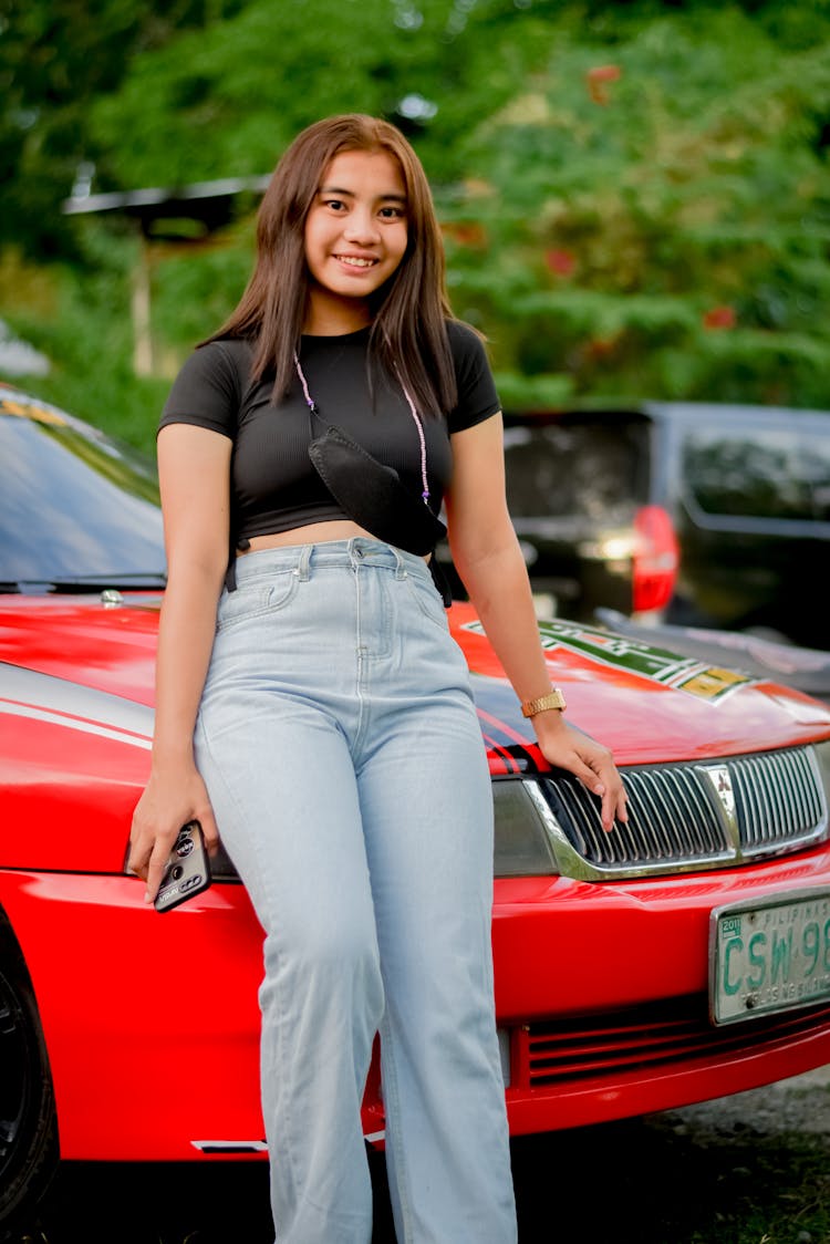 Teenage Girl Leaning On A Red Car