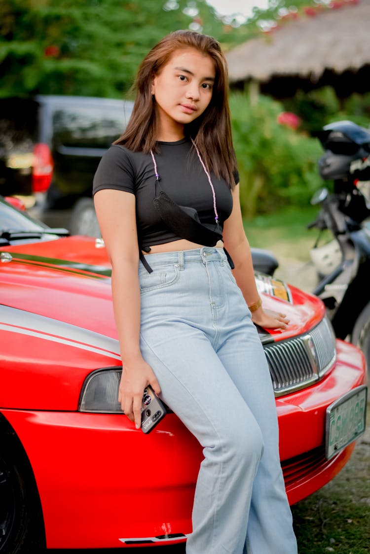 Girl Leaning On A Hood Of A Red Car