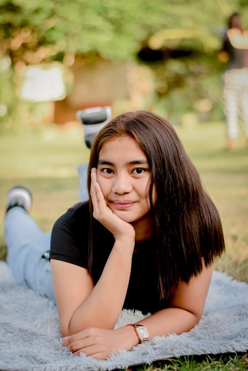 Portrait of a Brunette Girl Lying Down on Blanket in a Park