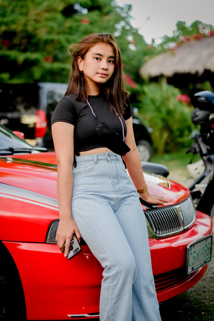 A Girl Leaning On A Red Car