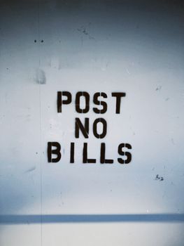Close-up of 'Post No Bills' sign on a textured wall in Vancouver, WA.