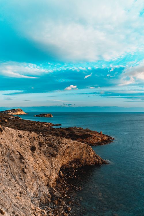 Free Beautiful coastal view featuring rocky cliffs and a vibrant sky over the ocean, ideal for nature lovers. Stock Photo