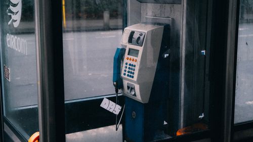 Free A vintage telephone booth with a payphone in an urban setting, showcasing retro technology. Stock Photo
