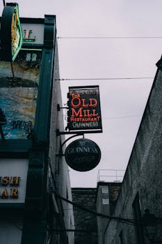 Low angle view of neon signs at The Old Mill Restaurant in Dublin's iconic pub district.