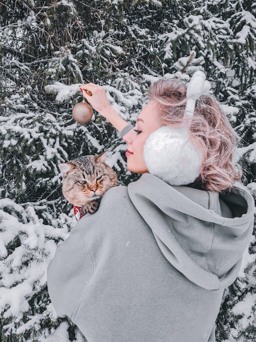 Woman in Gray Hoodie Jacket Holding Orange Tabby Cat