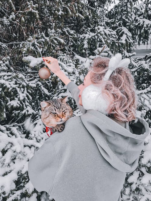 Woman in Gray Coat Holding Brown Tabby Cat