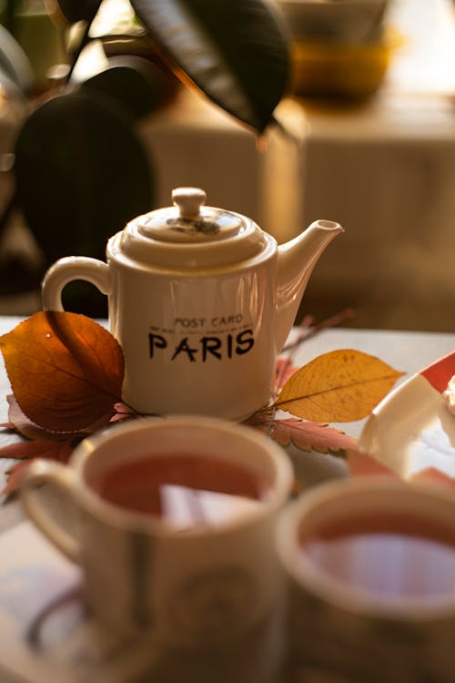 Free Teapot on Autumn Leaves and Teacups Stock Photo