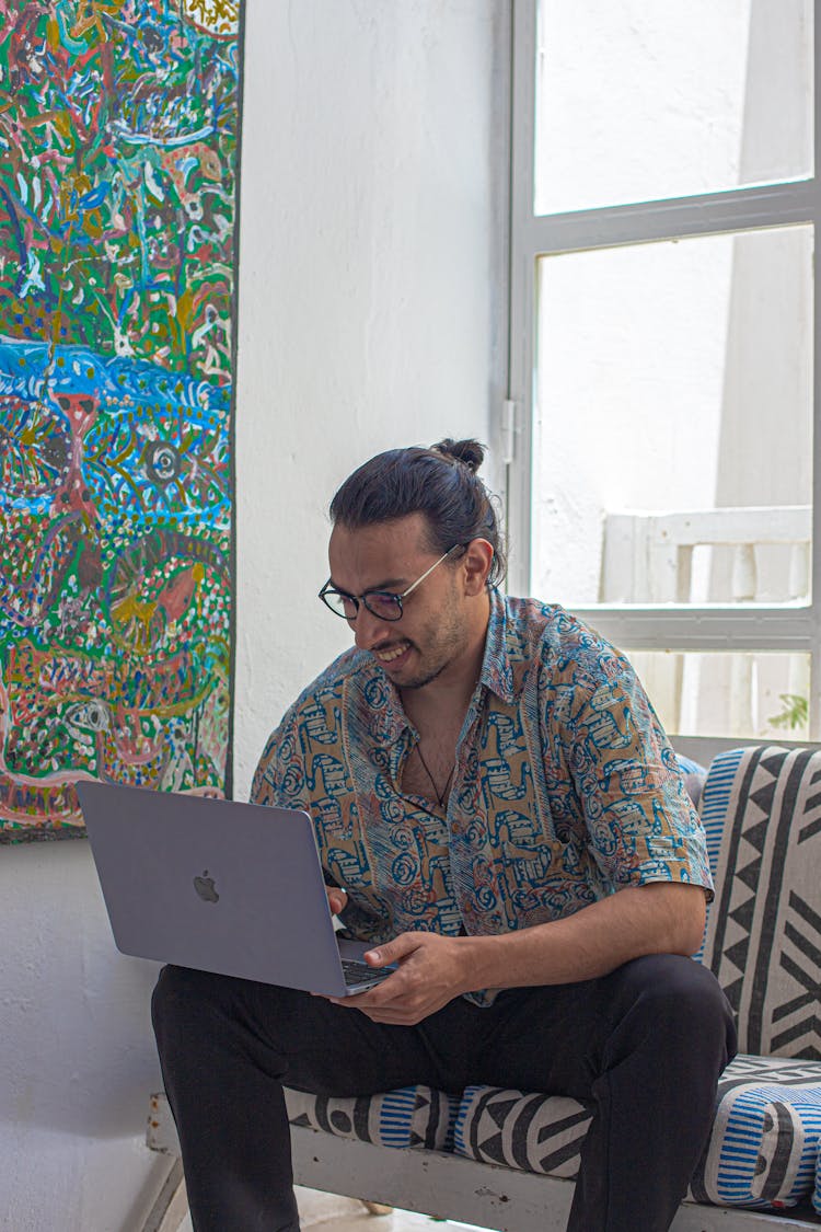 Young Fashionable Man Holding A Laptop And Smiling 