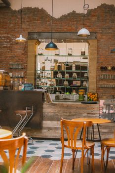 Cozy café interior featuring a rustic brick wall and wooden furniture.