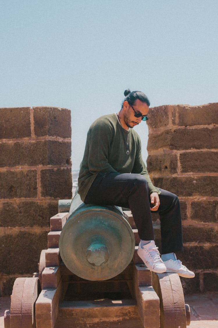 Man Sitting On A Cannon On A Castle 