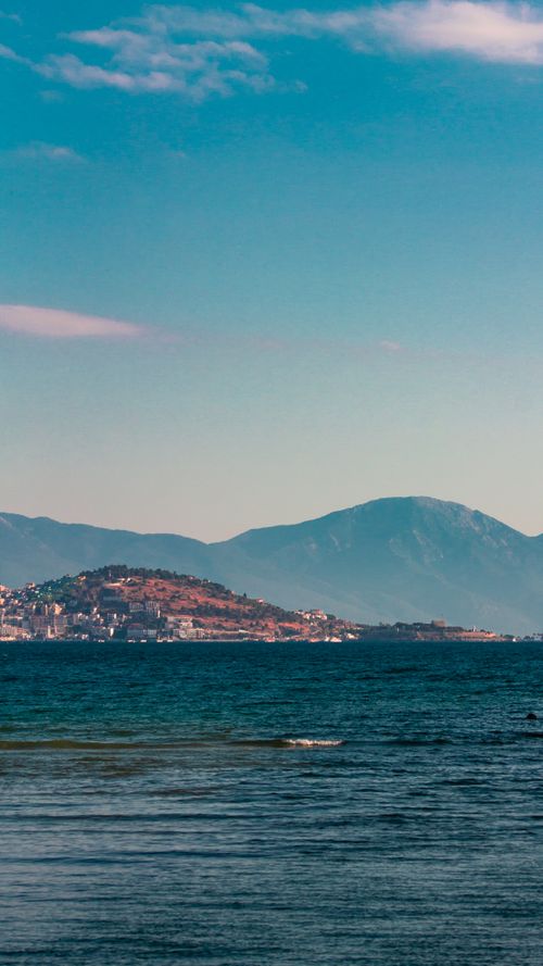 Free A breathtaking shot of Kuşadası coastline in Turkey highlighting the sea, mountains, and clear sky. Stock Photo