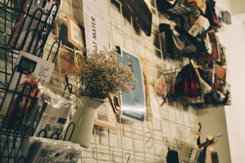 Free A rustic indoor wall decorated with magazines and a vase of flowers. Stock Photo