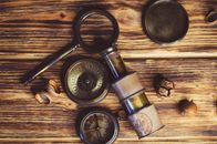 Black Magnifying Glass Beside Silver Pocket Watch
