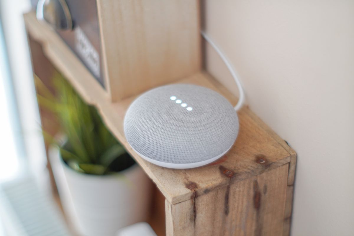 A round smart speaker on a wooden surface ready for voice commands