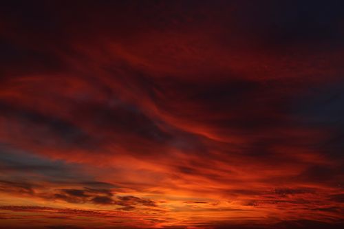 Free A captivating view of a fiery sunset casting dramatic hues across storm clouds, painting the sky in red and orange tones. Stock Photo