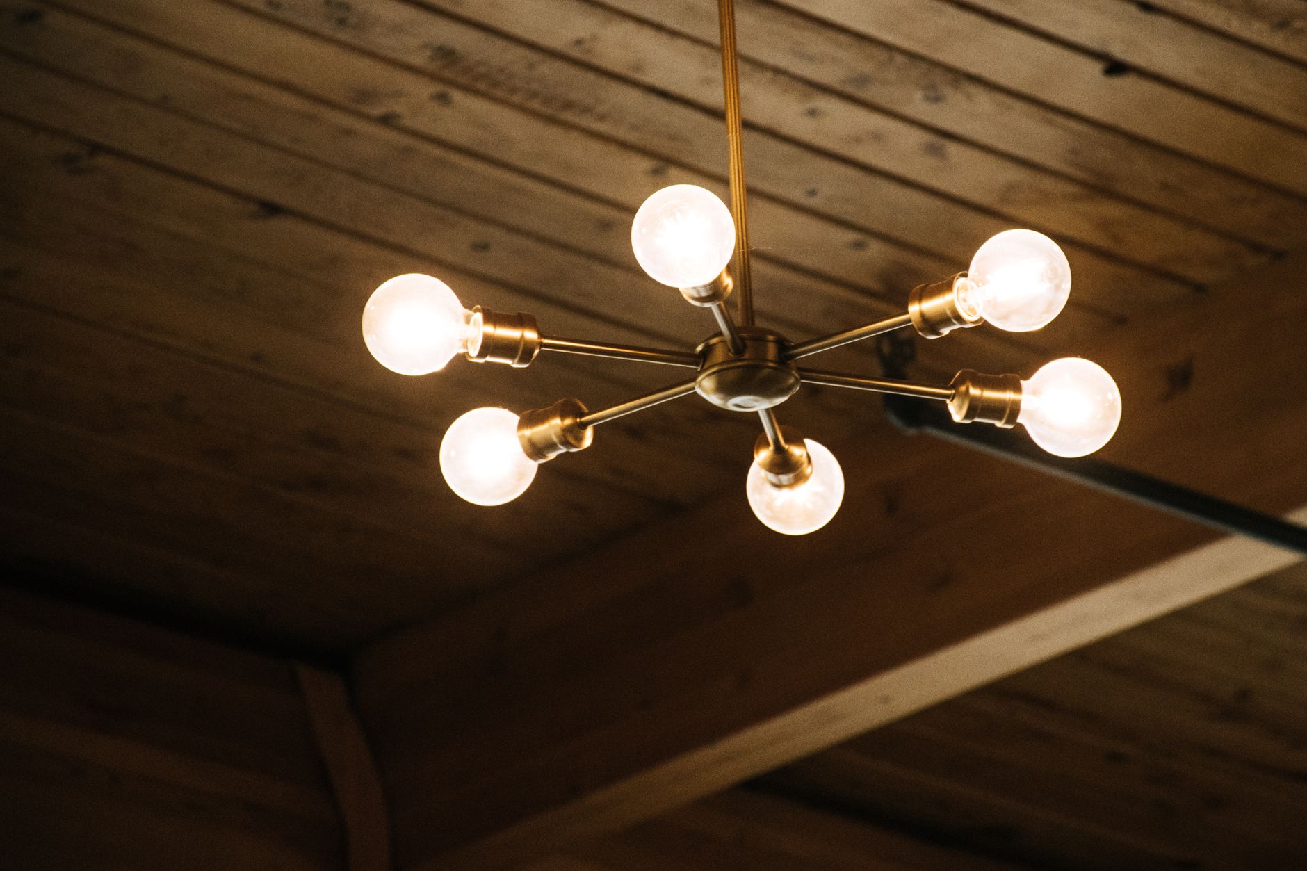 How to Match Fixtures and Bulbs Bought from Home Depot Stylish chandelier illuminating a wooden ceiling, creating a warm and inviting atmosphere indoors