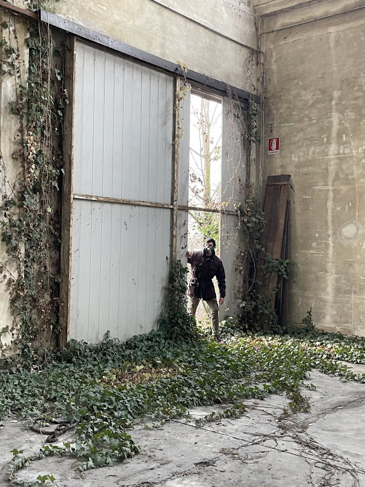 Man Near Garage Doors Of Abandoned Building